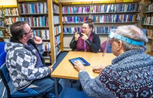 Ivon Peters receives advice from volunteer digital champion, David Smith, and his support worker, Kat Puckett