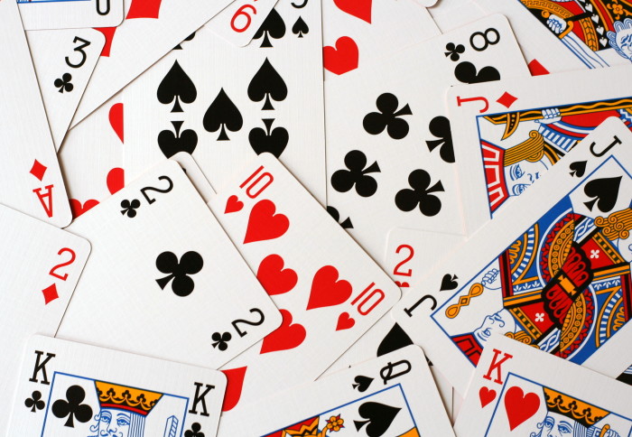 A deck of cards scattered on a table in a disorderly way