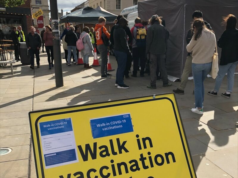 Queue of people waiting to receive their vaccination at the pop-up vaccination unit in Queen Street, Exeter