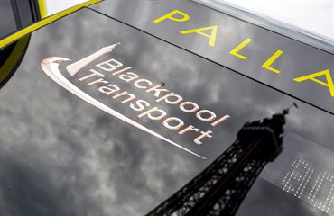 Logo on back of a bus with Blackpool Tower reflected in the glass