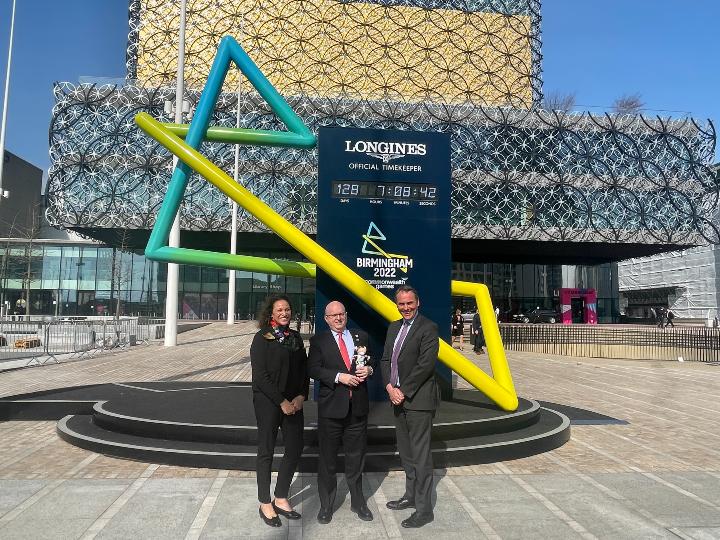 Council Chief Exec, US Ambassador and Council Commonwealth Games Programme Director stood infront of Games countdown clock and Library of Birmingham