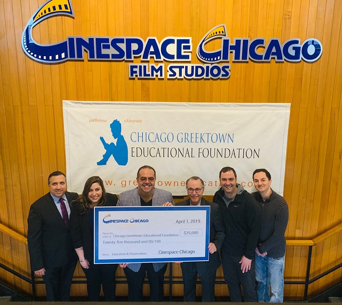 Alex Pissios and group displays check denoting charitable donation.