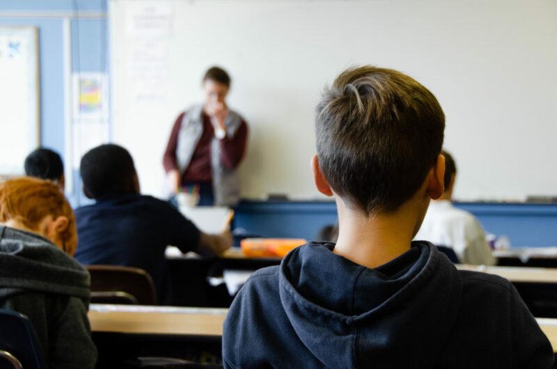 boy sat with back to camera, facing the front of the class
