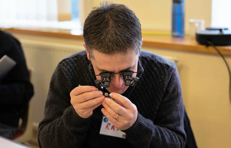 A volunteer fixer wearing watch-makers eye glasses