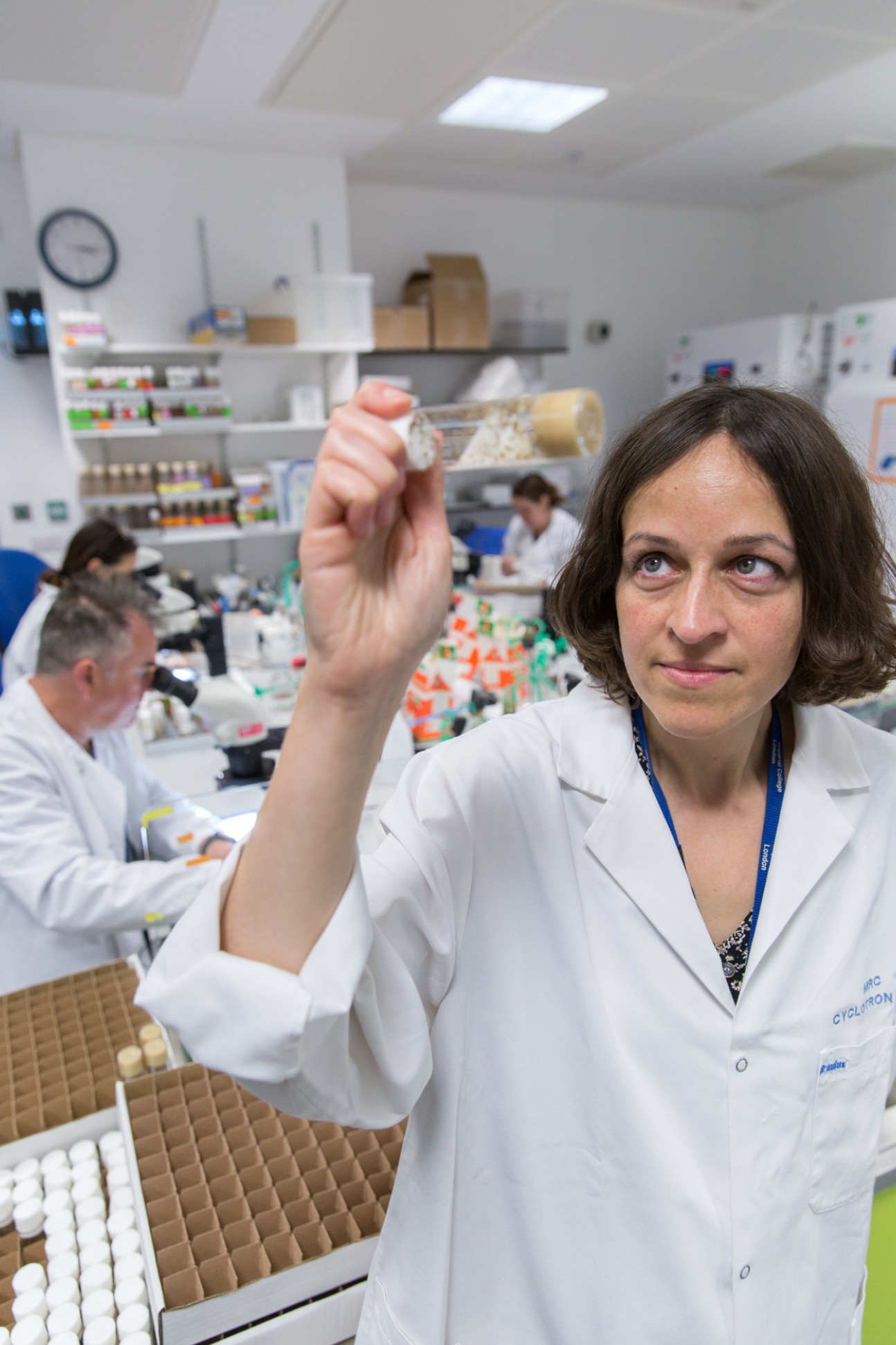 Professor Irene Miguel-Aliaga holds up a tube containing flies in a lab