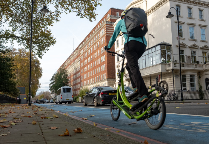 Rider on foldable bicycle using London cycle lane
