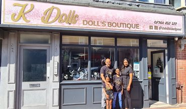 Family stood out a shop front smiling
