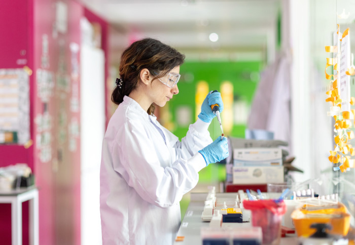 A researcher using a pipette in a lab
