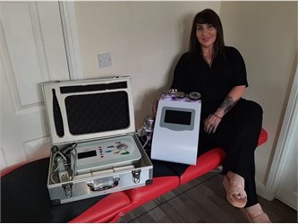 Woman sat next to two devices on a table