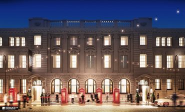Large British building front in the evening, with red telephone boxes outside