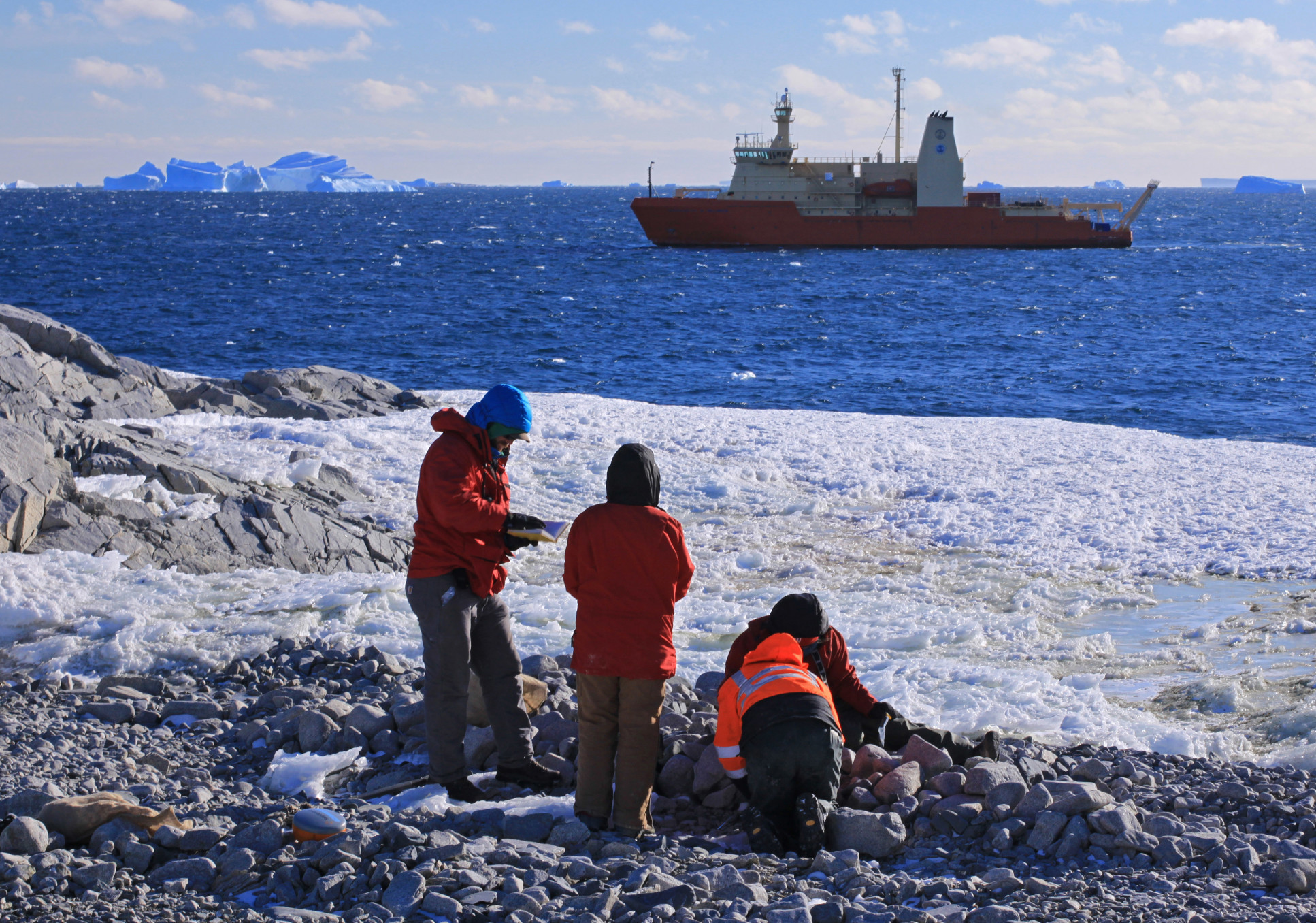 Photo of researchers collecting samples for radiocarbon dating on Lindsey Island beach