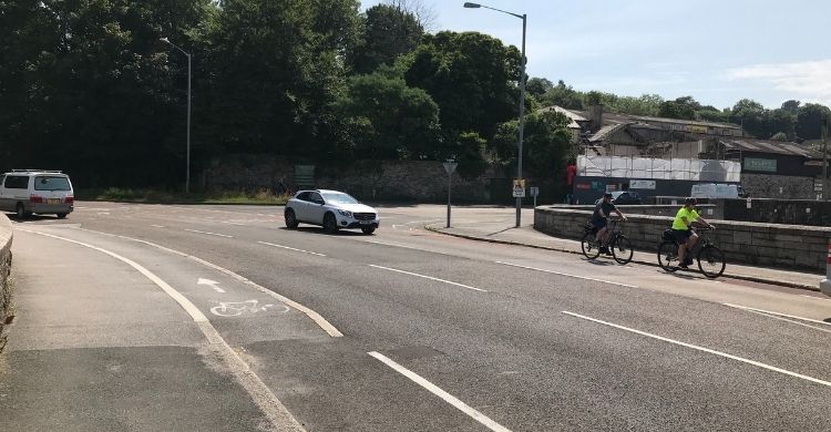 Two cars and two cyclists on a road