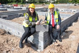 Cllr Gillian Campbell and Cllr Ivan Taylor sitting on one of the foundations