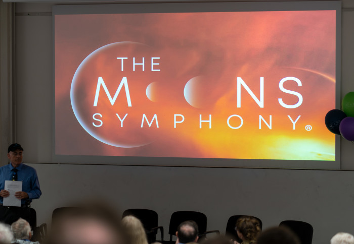 A screen projecting the words The Moons Symphony