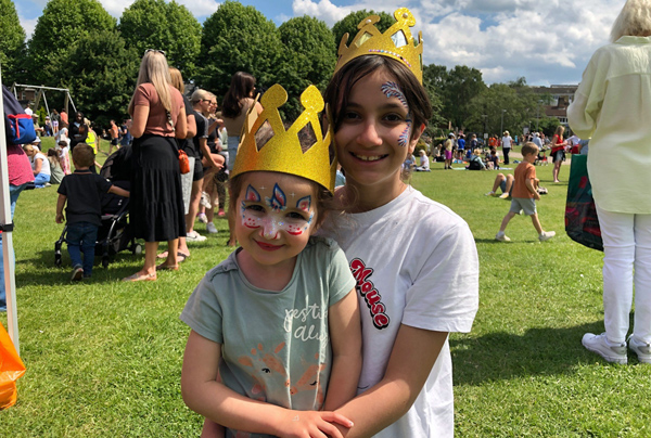 Two children with their faces painted and wearing homemade crowns