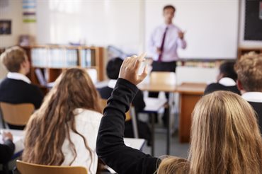 Student with hand raised in class