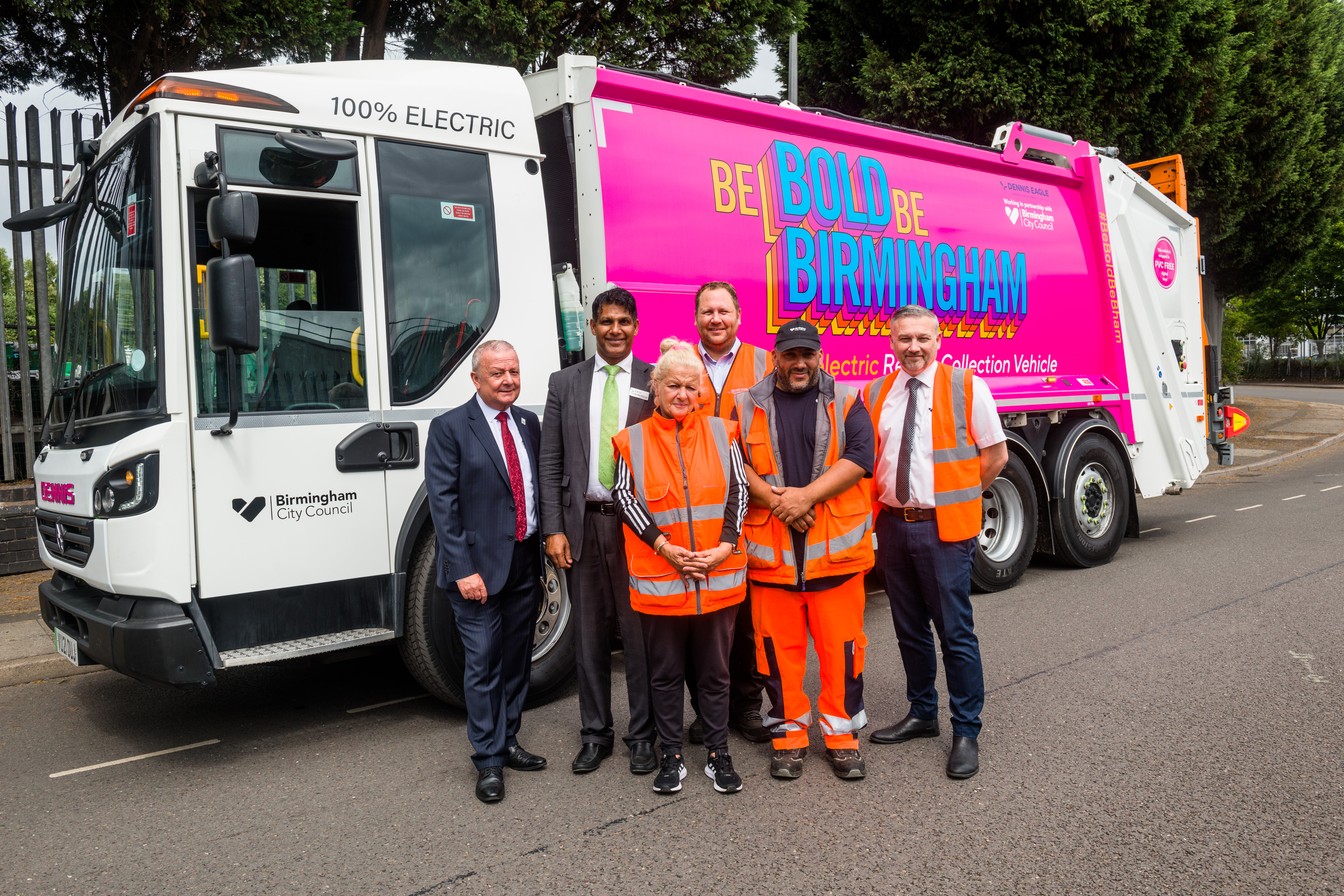 Image of new electric waste vehicle with Be Bold Be Birmingham branding - and group of waste workers with Rob James, Strategic Director - City Operations and Cllr Majid Mahmood, Cabinet Member for Environment