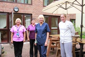 Infection nurse with care home staff in garden area