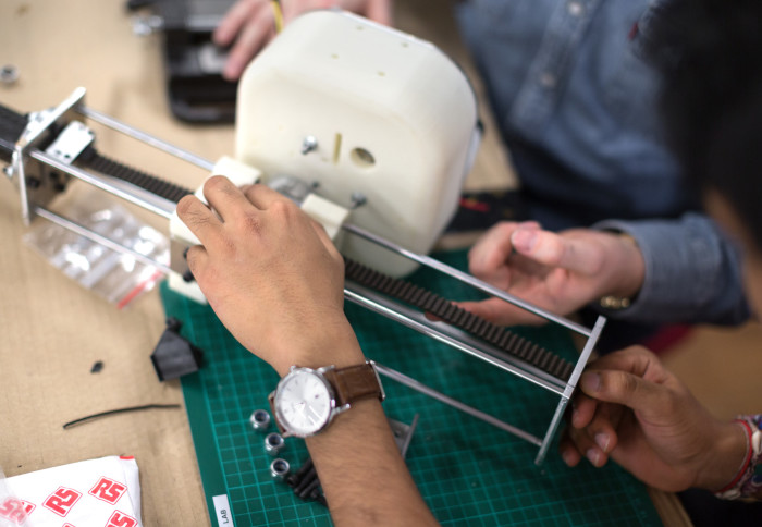 Students at the Dyson School of Design Engineering Robot Intelligence Lab working on a project to build a slider for the legged robot.