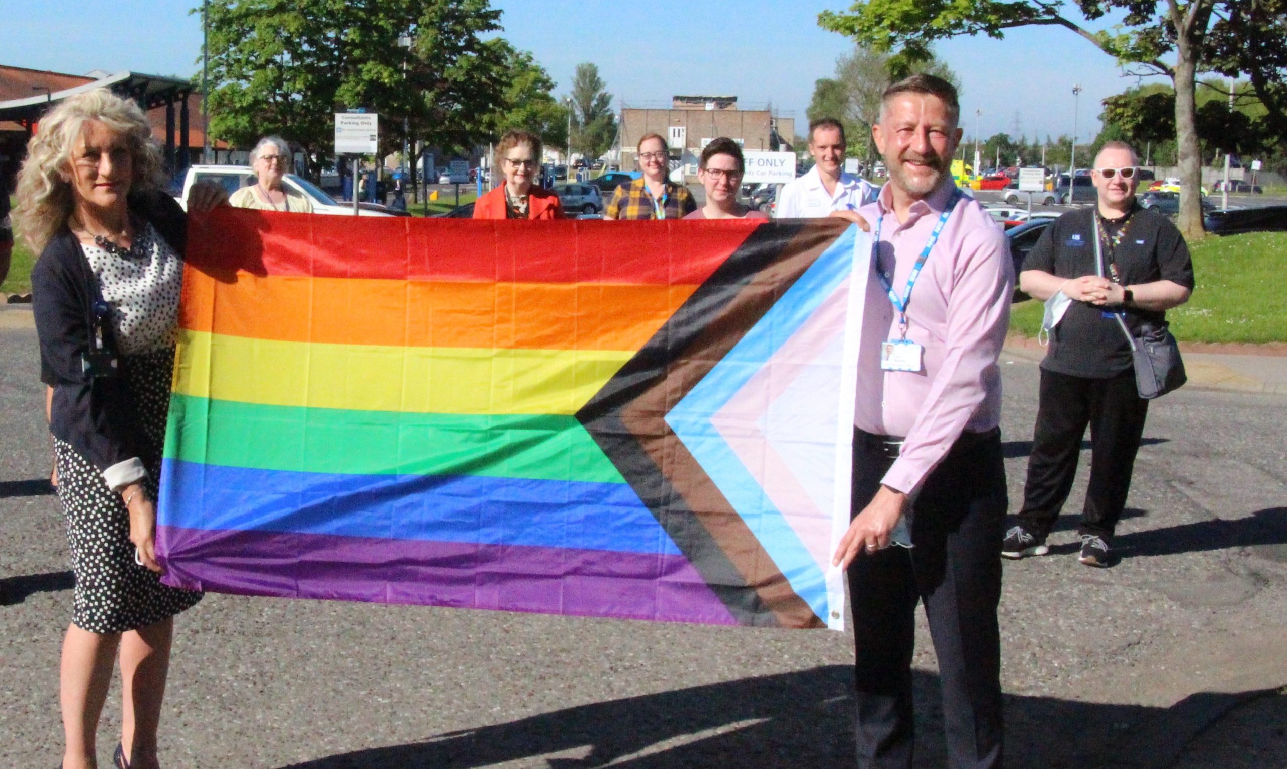 Staff raise the LGBTQ+ flag during Pride.