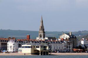 Scene of Weymouth town and beach with the pier and church spire.