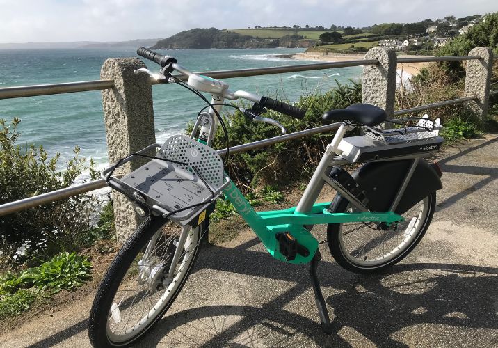 Photo shows an e-bike with a coastal scene in the background