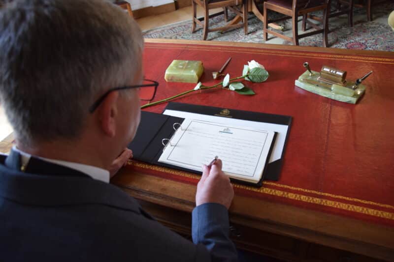 Chairman of Devon County Council, Cllr Ian Hall, signing the Book of Condolence