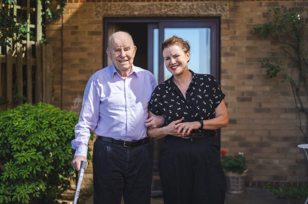 Carer supporting elderly man