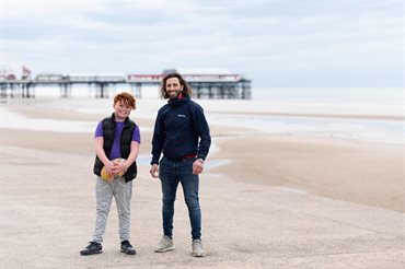 boy-and-older-man-on-Blackpool-beach-smiling-min