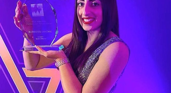 Art lecturer Rupinder Sandhu holding her glass award