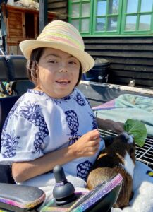 Girl in straw hat in electric wheelchair