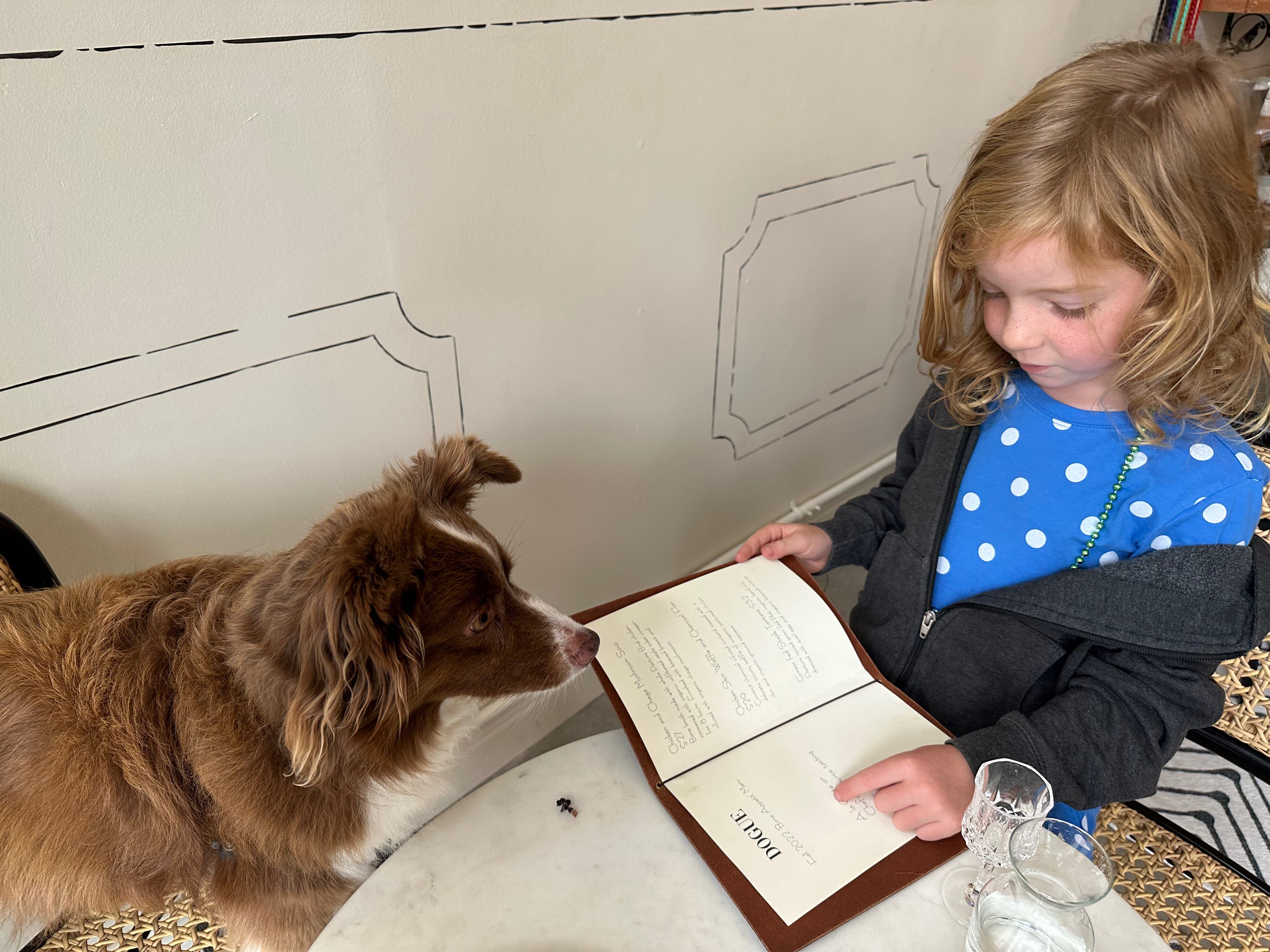 My daughter reads my dog the menu.