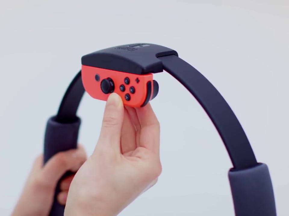 Person holding a Nintendo Switch controller while playing "Ring Fit Adventure"