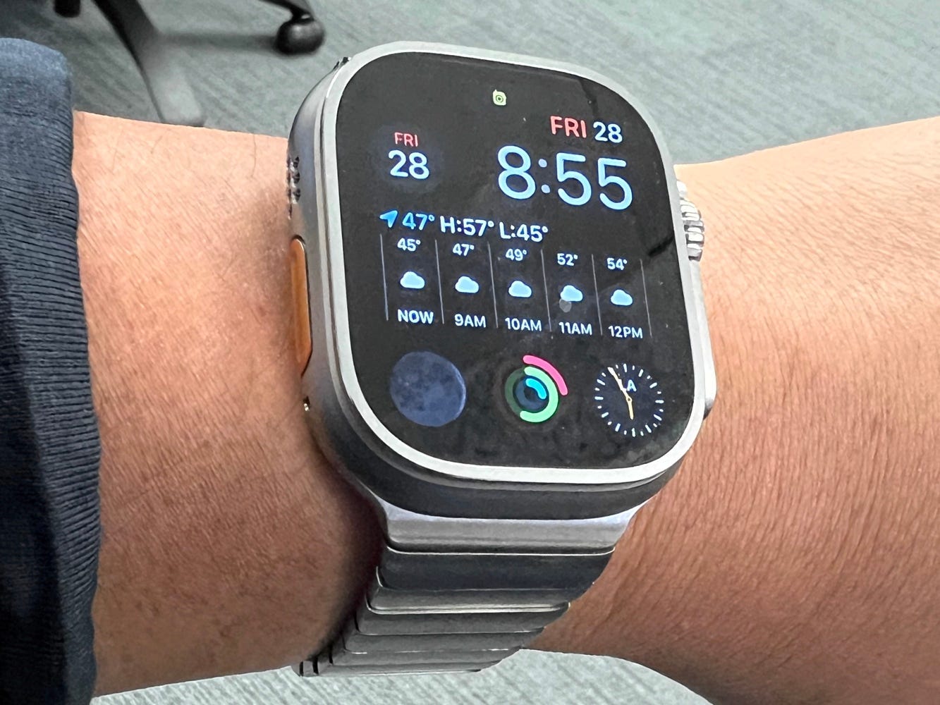 A man's wrist wearing an Apple Watch Ultra with the stainless steel metal band.