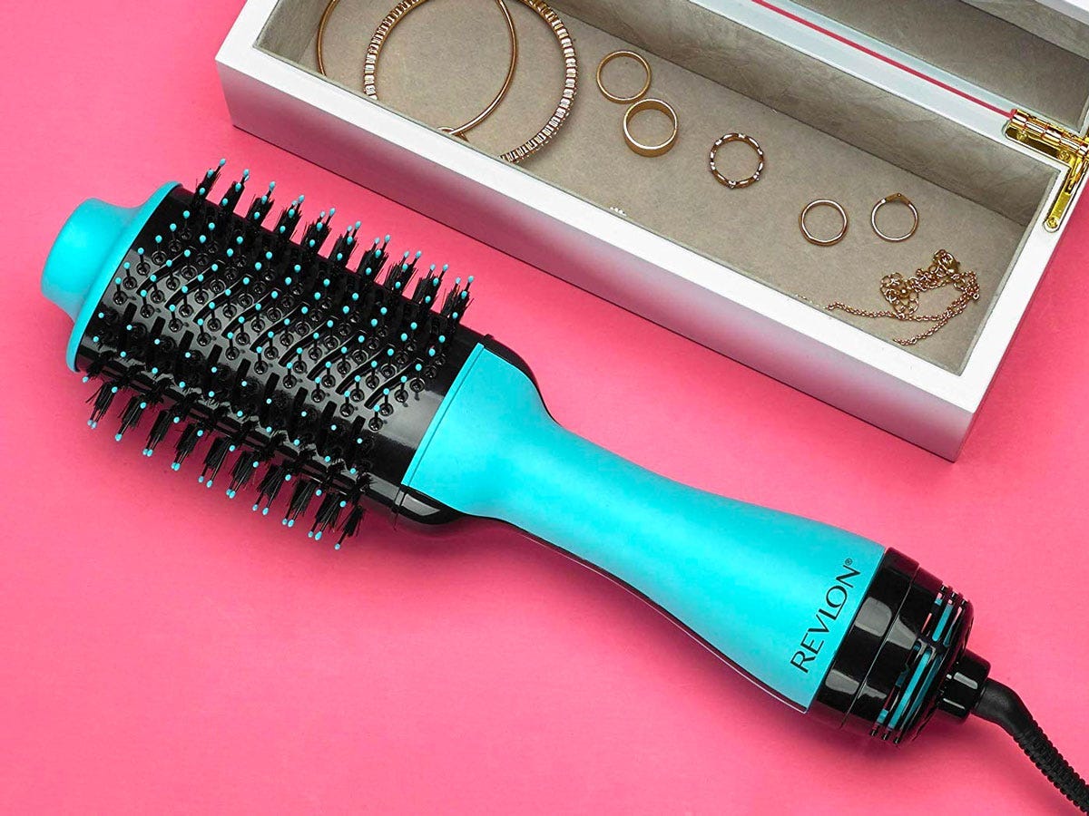 revlon one-step hair dryer brush on a tabletop next to a jewelry box filled with rings and earrings.