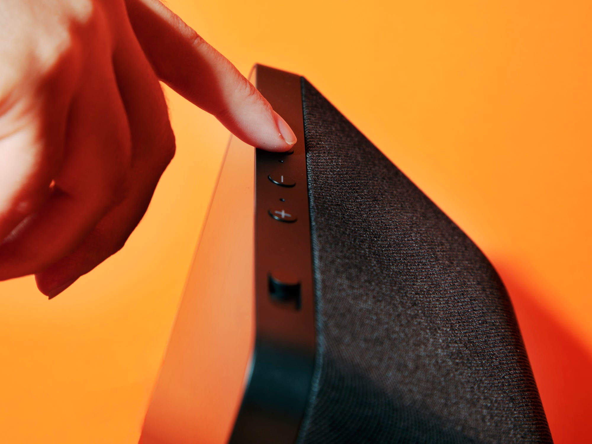 A person pressing a button on the Amazon Echo Show 8 smart display.