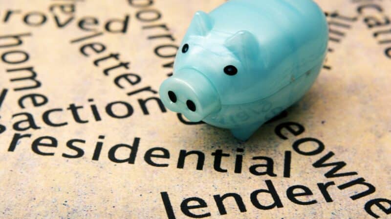 A piggy bank on a piece of paper that has the word 'lender' typed on it