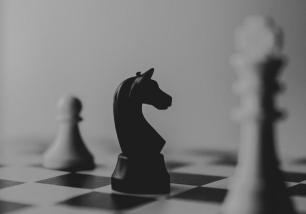 black horse chess piece near roque chess piece