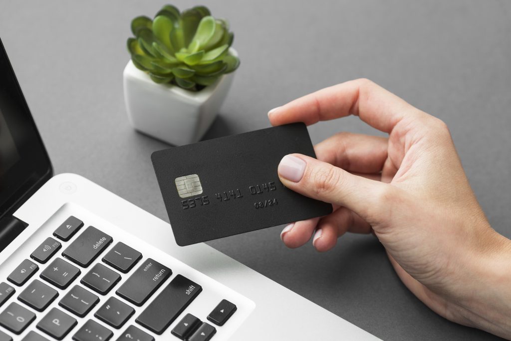 A person holding a Credit Card trying to use benefits while spending online