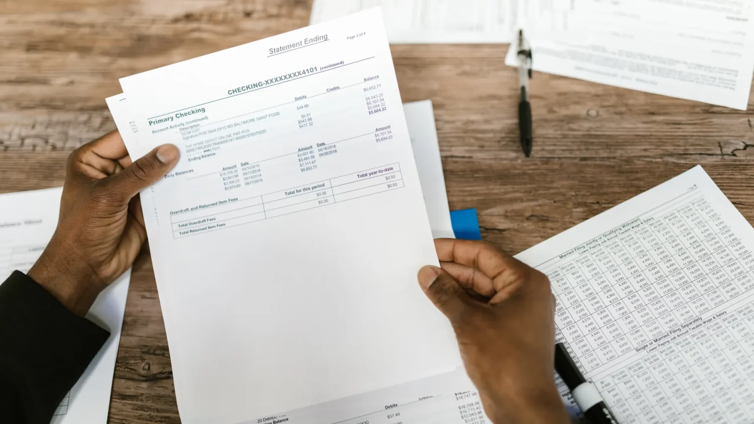 Organized desk with financial documents, calculator, and checklist for annual financial review