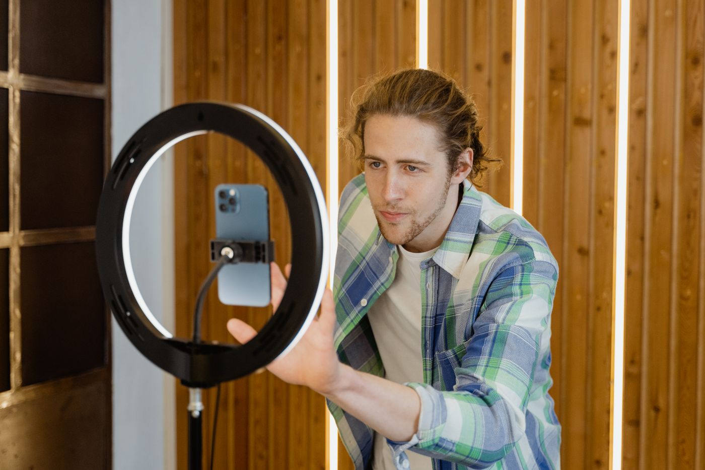 A creator setting up a smartphone and ring light to record a short video