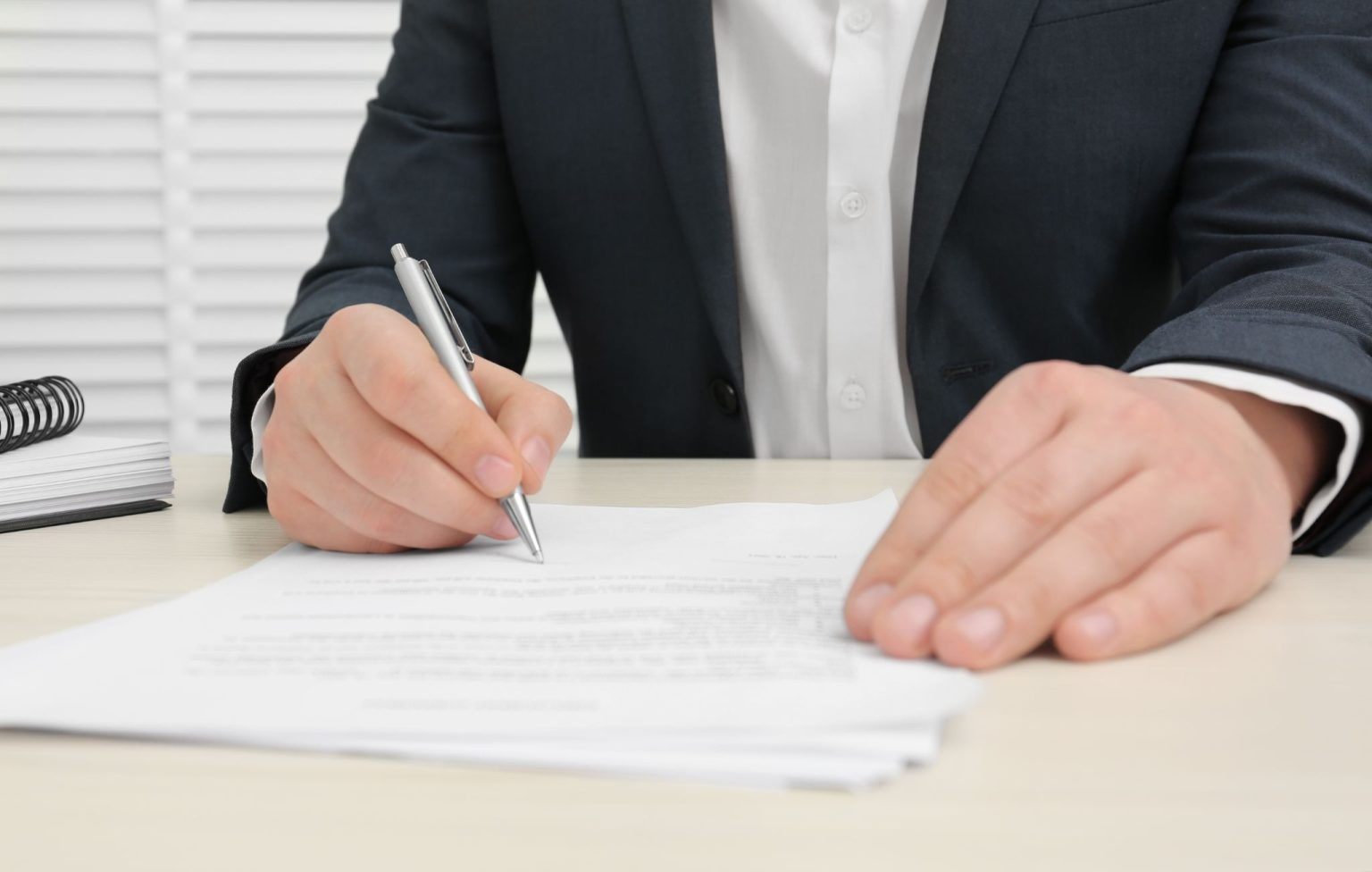 Steven Capuano on the Warranty and Returns Documents That Quietly Set a Product’s Margin A businessman signing product documents at a desk, illustrating warranty and returns paperwork