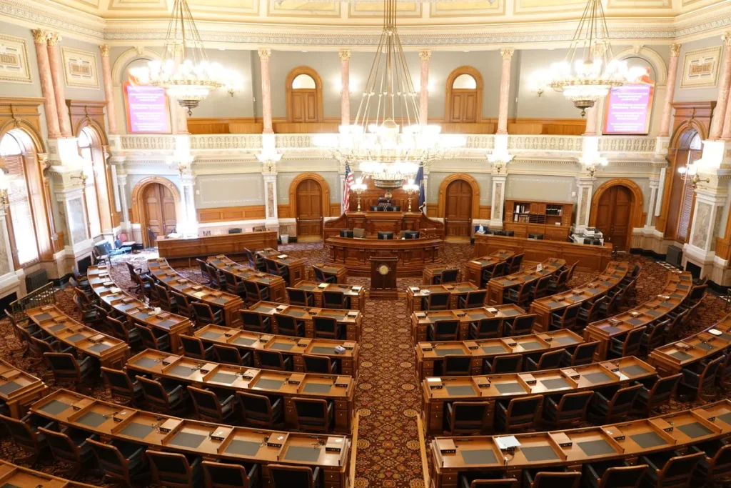 Defected MS likens Reform UK’s handling of criticism to abuser tactics Wide view of an ornate legislative chamber with empty seats and chandeliers