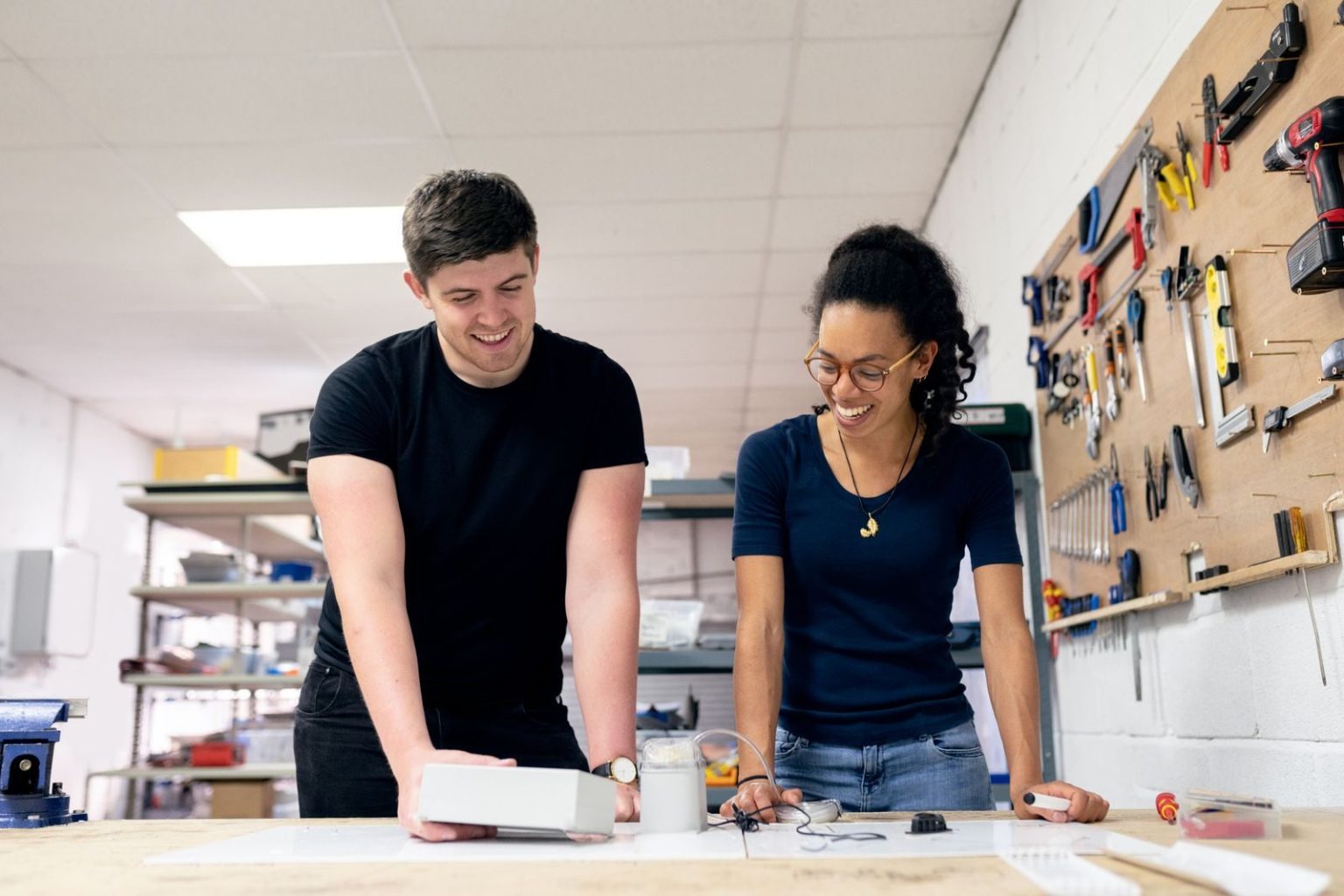 Two engineers working on a product prototype at a workshop bench