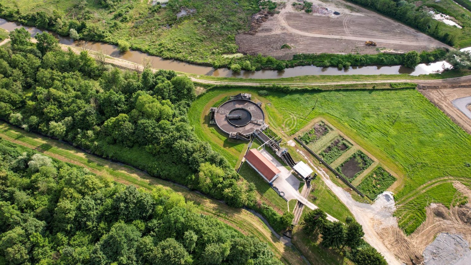 Environment Secretary promises tougher action on water bosses after first joint regulator report A river running past a water treatment works in the English countryside