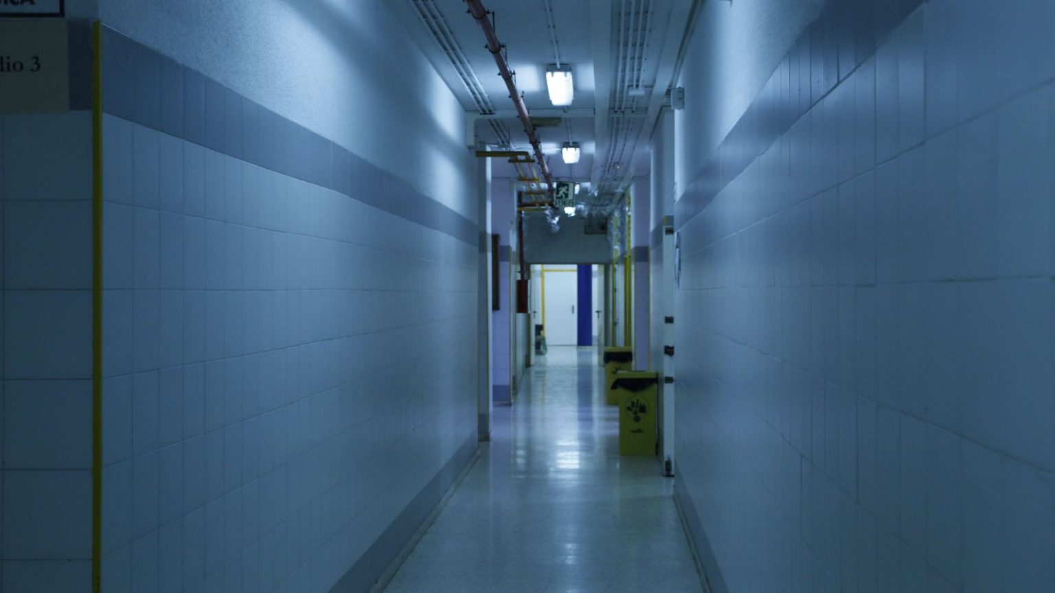 An empty hospital corridor with doors along one side