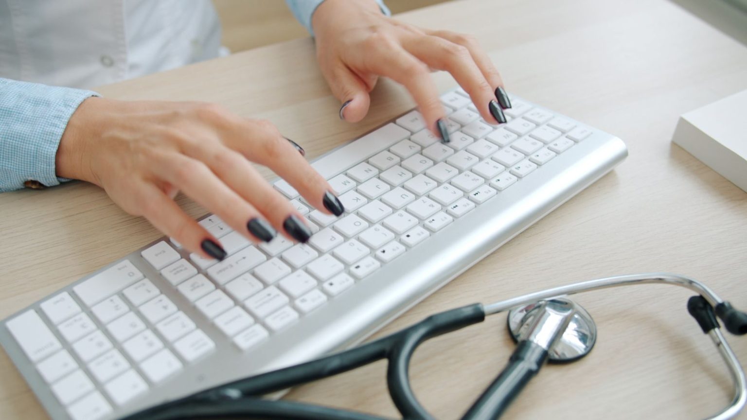 Nihit Gurram on the Difference Between a Correct Prediction and a Useful One A clinician typing into an electronic health record with a stethoscope on the desk