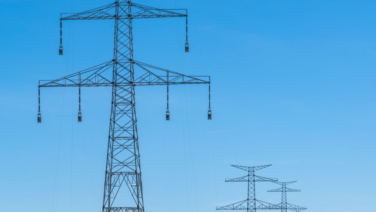 Electricity pylons crossing open countryside