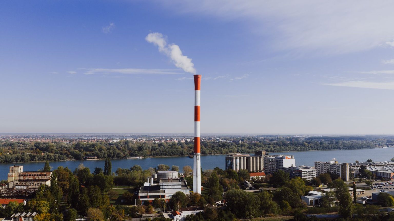 UK greenhouse gas emissions fall 1.0 per cent to 473 million tonnes Industrial chimneys and a road under an overcast UK sky
